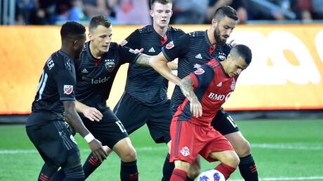 Toronto FC forward Sebastian Giovinco (10) controls the ball as D.C. United players Oniel Fisher, left to right, Frederic Brillant, Chris Durkin and Steve Birnbaum try to box him in during the first half. toronto-dc