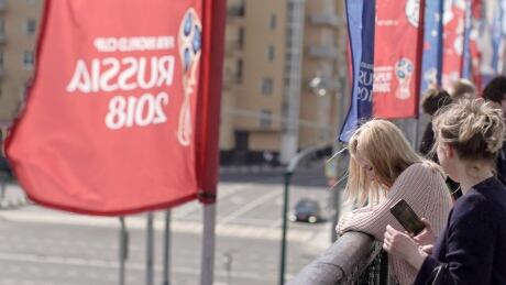 Women look over from the Krymsky Bridge, adorned with banners of the World Cup in Moscow on Wednesday. A senior Russian lawmaker advised Russian women Wednesday to be vigilant during any romantic encounters with foreign fans flocking to Russia for the World Cup so as not to end up raising their children alone. World Cup romance