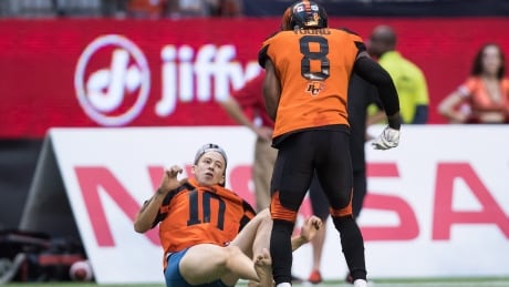 B.C. Lions' Marcell Young (8) knocks down a spectator that ran onto the field of play during the first half of a CFL football game against the Montreal Alouettes in Vancouver, on Saturday June 16, 2018. THE CANADIAN PRESS/Darryl Dyck FBO CFL Alouettes Lions 20180616