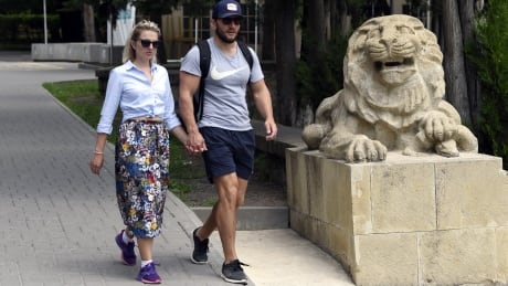 A couple walk past a stone lion at the Essentuki Therapeutic Mud Baths in Essentuki, a city in Stavropol Krai at the base of the Caucasus Mountains, southern Russia on June 16, 2018. - Essentuki, is reputed as the cultural capital of Russia's Greek population having the highest population of Greek descent in the country. Essentuki is home to the Nigerian national football team the Super Eagles during the Russia World Cup 2018. Couple walk