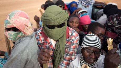 Nigeriens and third-country migrants head towards Libya from Agadez, Niger, Monday, June 4, 2018. Every Monday evening, convoys filled with the hopeful pass through a military checkpoint at the edge of the city, bringing jugs of water. (AP Photo/Jerome Delay) Sahara Walk Or Die