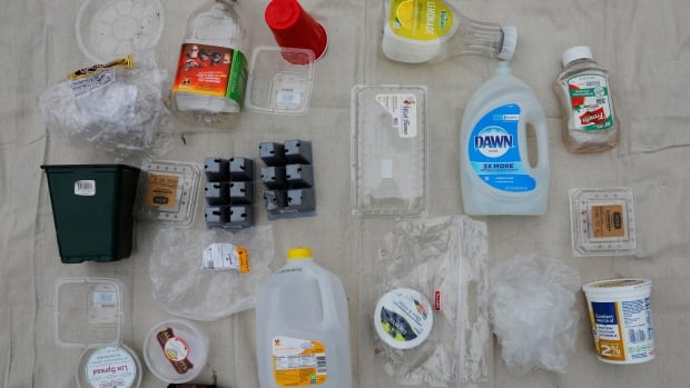 An assortment of household plastic containers, bottles and packaging laid out for display.