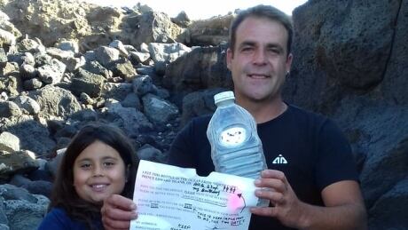 Daniel and Rafaela Pamplona hold the bottle and note they found on the beach. Daniel and Rafaela Pamplona