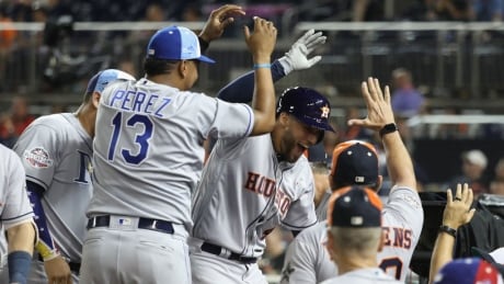 Houston Astros' George Springer celebrates with teammates after hitting a solo home run in the tenth inning. springer-george