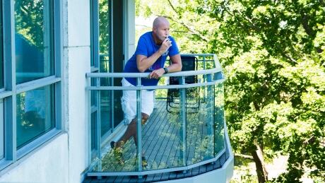 Gerald Major, 46, uses a vaporizer with medical marijuana on his back balcony at his condo in Oakville, Ont., to ease severe arthritis pain. Condos Smoking Pot 20180718