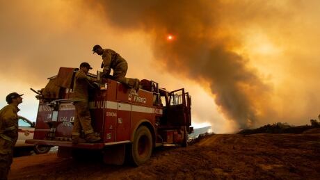 Firefighter Joe Smith retrieves supplies while battling the Ranch Fire, part of the Mendocino Complex Fire, burning along High Valley Rd near Clearlake Oaks, California, on August 5, 2018. - Several thousand people have been evacuated as various fires swept across the state, although some have been given permission in recent days to return to their homes. AFP_1857PL