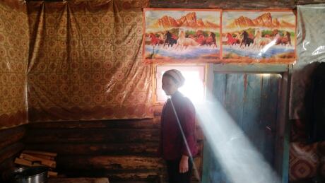 Local villager Yonghong stands next to a window in a log cabin at Khom village of Altay, Xinjiang Uighur Autonomous Region, China, on Jan. 27, 2018. CHINA-SKIING/
