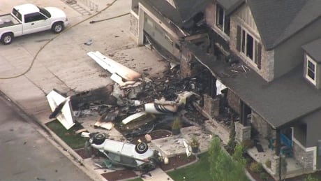 This frame from video shows the scene of a small plane that crashed into a house in Payson, Utah, on Monday, Aug 13, 2018. Authorities said the pilot was killed in the crash. Plane Into House