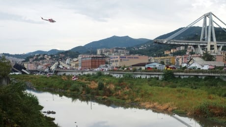 A firefighter helicopter flies over the collapsed Morandi highway bridge in Genoa. Authorities had placed the death toll about four hours after the incident at around 20 people, with the chance it could increase.<br />
<br />
<br />
Italy Highway Collapse