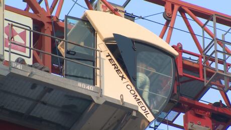 Firefighters are trying to determine how to bring down a woman inside a downtown crane. Woman on crane