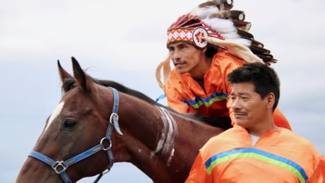 Tyson Head helps rider Dylan Singer warm up before an Indian relay event on August 13 in Saulteaux First Nation in central Saskatchewan. Indian relay