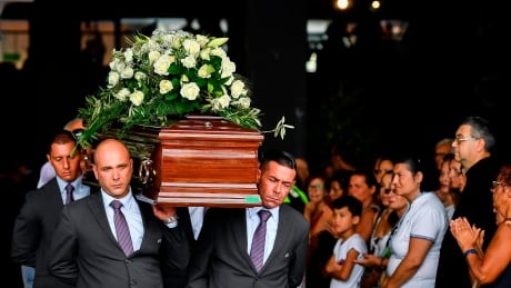 Pallbearers carry a coffin during a funeral service for some of the victims of a collapsed highway bridge, in Genoa's exhibition center Fiera di Genova, Italy, Saturday, Aug. 18, 2018. The death toll from Tuesday's disaster has surpassed 40. Italy Bridge Collapse