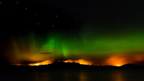 Wildfire fringes the night sky at Fraser Lake, with the northern lights in the background. B.C. Wildfire/northern lights.