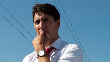 Prime Minister Justin Trudeau listens to a presentation between two signs, before participating in a ground breaking ceremony for a distribution centre in Ottawa, Monday August 20, 2018. THE CANADIAN PRESS/Adrian Wyld PM Ground Breaking 20180820