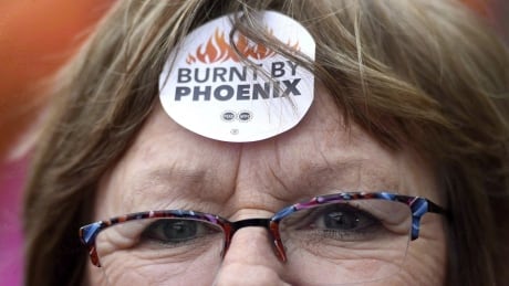 Shirley Taylor wears a "Burnt by Phoenix" sticker on her forehead during a rally against the Phoenix payroll system outside the offices of the Treasury Board of Canada in Ottawa on Wednesday, Feb. 28, 2018. The federal government says the recent hiring of new staff at its pay centre in Miramichi, N.B., has helped cut the backlog of problem files created under the troubled Phoenix pay system. Phoenix pay Problems 20180608