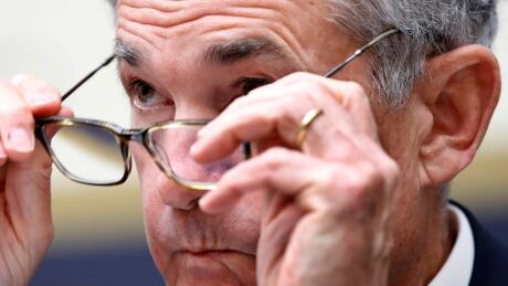 FILE- In this July 18, 2018, file photo Federal Reserve Board Chair Jerome Powell put on his glasses while testifying during a House Committee on Financial Services hearing on Capitol Hill in Washington. Powell gives the keynote address Friday, Aug. 24, at an annual conference of central bankers in Jackson Hole, Wyo. (AP Photo/Jacquelyn Martin, File) Federal Reserve Powell