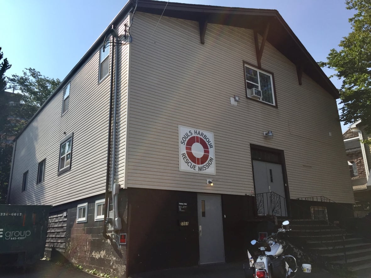 A beige two storey building seen from the outside, with a sign saying Souls Harbour Rescue Mission on the front with a red life-preserver.