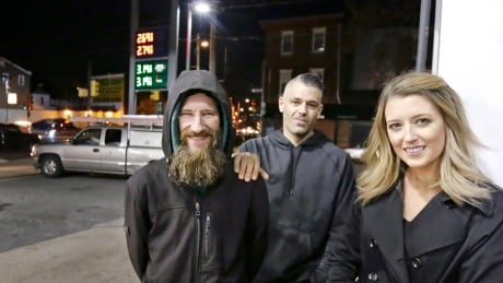 FILE- In this Nov. 17, 2017, photo, Johnny Bobbitt Jr., left, Kate McClure, right, and McClure's boyfriend Mark D'Amico pose at a Citgo station in Philadelphia. When McClure ran out of gas, Bobbitt, who is homeless, gave his last $20 to buy gas for her. McClure started a Gofundme.com campaign for Bobbitt that has raised more than $275,000. (Elizabeth Robertson/The Philadelphia Inquirer via AP, File) Helpful Homeless Man