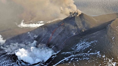 Aerial view of the eruption at Mount Veniaminof's intracaldera cone on the Alaska Peninsula, in this photo taken August 18, 2013 courtesy of AVO/USGS. This cone rises about 1000 feet above the surrounding icefield. It has been intermittently erupting lava, ash and steam since June 13, 2013. This photo shows the incandescent, orange stream of molten lava emerging from the active cone. Steam billows from the pit at the base of the cone where the lava encounters and melts ice and snow. A small, ash-rich plume rises just above the vent producing a diffuse ash cloud that drifts downwind. In the foreground, round white patches probably represent ballistic impact craters. REUTERS/Game McGimsey/Alaska Volcano Observatory/U.S. Geological Survey/Handout (UNITED STATES - Tags: ENVIRONMENT) FOR EDITORIAL USE ONLY. NOT FOR SALE FOR MARKETING OR ADVERTISING CAMPAIGNS. THIS IMAGE HAS BEEN SUPPLIED BY A THIRD PARTY. IT IS DISTRIBUTED, EXACTLY AS RECEIVED BY REUTERS, AS A SERVICE TO CLIENTS - TM4E98U1F4201 Mount Veniaminof