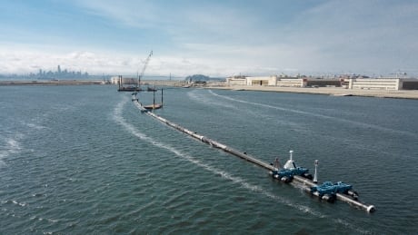 In this Monday, Aug. 27, 2018 photo provided by The Ocean Cleanup, a long floating boom that will be used to corral plastic litter in the Pacific Ocean is assembled in Alameda, Calif. Engineers will deploy a trash collection device to corral plastic litter floating between California and Hawaii in an attempt to clean up the world's largest garbage patch. The 2,000-foot (600-meter) long floating boom will be towed Saturday, Sept. 8, 2018, from San Francisco to the Great Pacific Garbage Patch, an island of trash twice the size of Texas. (The Ocean Cleanup via AP) Pacific Ocean Plastic Cleanup