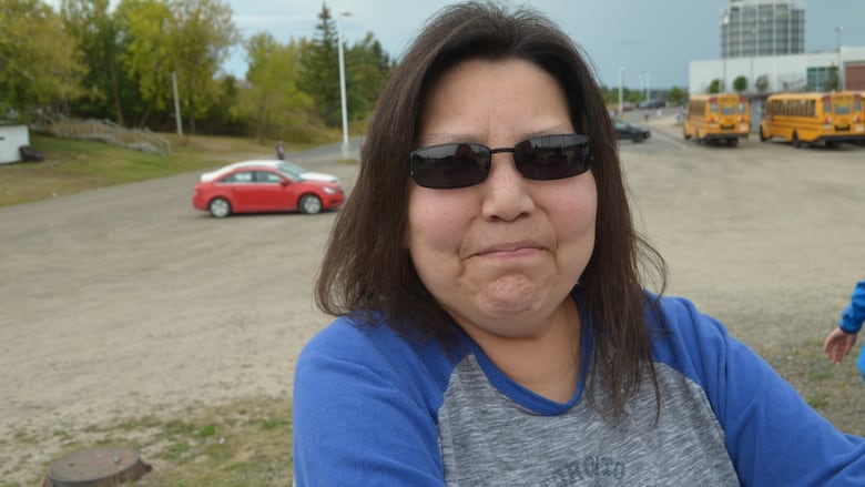 a woman in a grey and blue shirt takes a selfie