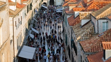 In this Sept. 7, 2018 photo, tourists walk through Dubrovnik old town. Crowds of tourist are clogging the entrances into the ancient walled city, a UNESCO World Heritage Site, as huge cruise ships unload thousands more daily. (AP Photo/Darko Bandic) Croatia Dubrovnik Crush