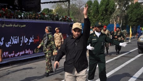 In this photo provided by the Iranian Students' News Agency, ISNA, security forces try to control the scene after a shooting during a military parade marking the 38th anniversary of Iraq's 1980 invasion of Iran, in the southwestern city of Ahvaz, Iran, Saturday, Sept. 22, 2018. Gunmen attacked the military parade, killing at least eight members of the elite Revolutionary Guard and wounding 20 others, state media said. (AP Photo/ISNA, Behrad Ghasemi) Iran