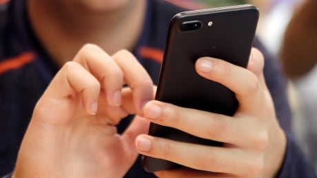 FILE - In this Sept. 16, 2017, file photo, a person uses a smart phone in Chicago. For many of us, a smartphone addiction is not so much a debilitating disease but a constant, nagging inconvenience we can’t seem to shake. But it’s not all our fault. From the constant notifications to the color schemes to the "likes," followers and in-game rewards out phones and the apps on them were created so we’ll use them as much as possible. But there are ways to fight back. (AP Photo, File) Digital Life Cutting Back on Tech