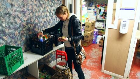 Katrina Charbonneau restocks essentials at the Foster Family food bank. Katrina Charbonneau