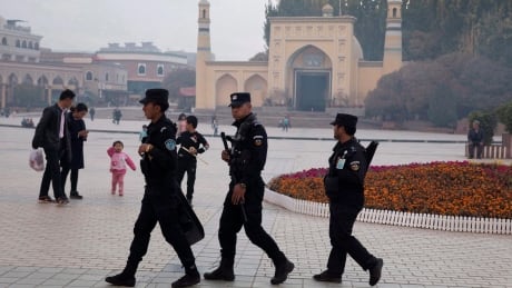 FILE - In this Nov. 4, 2017 file photo, Uighur security personnel patrol near the Id Kah Mosque in Kashgar in western China's Xinjiang region. China's northwestern region of Xinjiang has revised legislation to allow the detention of suspected extremists in "education and training centers." The revisions come amid rising international concern over a harsh crackdown in Xinjiang that has led to as many as 1 million of China's Uighurs and other Muslim minorities being held in internment camps. (AP Photo/Ng Han Guan, File) China Internment Camps