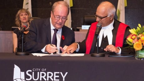 Surrey Mayor Doug McCallum, left, is sworn in during an inauguration ceremony in Surrey, B.C. on Monday, November 5, 2018 in this handout photo. Surrey RCMP 20181109