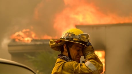 A firefighter keeps watch as the wildfire burns a home near Malibu Lake in Malibu, Calif., Friday, Nov. 9, 2018. California Wildfires Photo Gallery