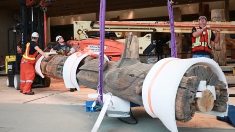 Workers lay a totem on its back before relocating it out of the MOA's great hall and into an adjacent gallery. MOA totems