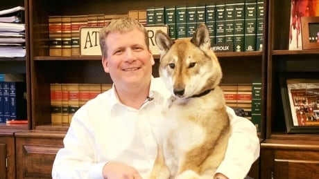 Attleboro, Massachusetts Mayor Paul Heroux poses for a photo in city hall with his dog, Mura. Mura is facing terminal cancer and her owner took her on a last road trip to Vancouver Island. Paul Heroux and Mura