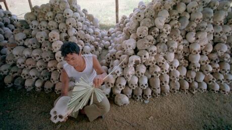 A man cleans a skull near a mass grave at the Chaung Ek torture camp run by the Khmer Rouge in this undated photo. The last surviving leaders of the communist Khmer Rouge regime that brutally ruled Cambodia in the 1970s were convicted of genocide, crimes against humanity and war crimes by an international tribunal. Cambodia Khmer Rouge