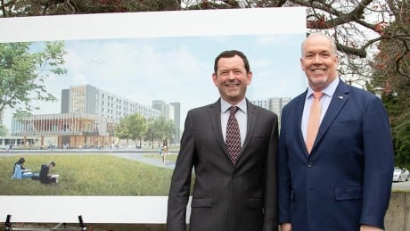 Premier John Horgan and UVic president Jamie Cassels pose for a photograph in front of a rendering of new residence buildings at the University of Victoria. uvic housing announcement