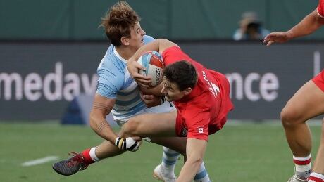 Canada's Matt Mullins, right, seen in a previous match, helped Canada build a first-half lead against Argentina, but two yellow cards to Canada sparked a Puma comeback with three-straight tries. canada-rugby-sevens-men-072018