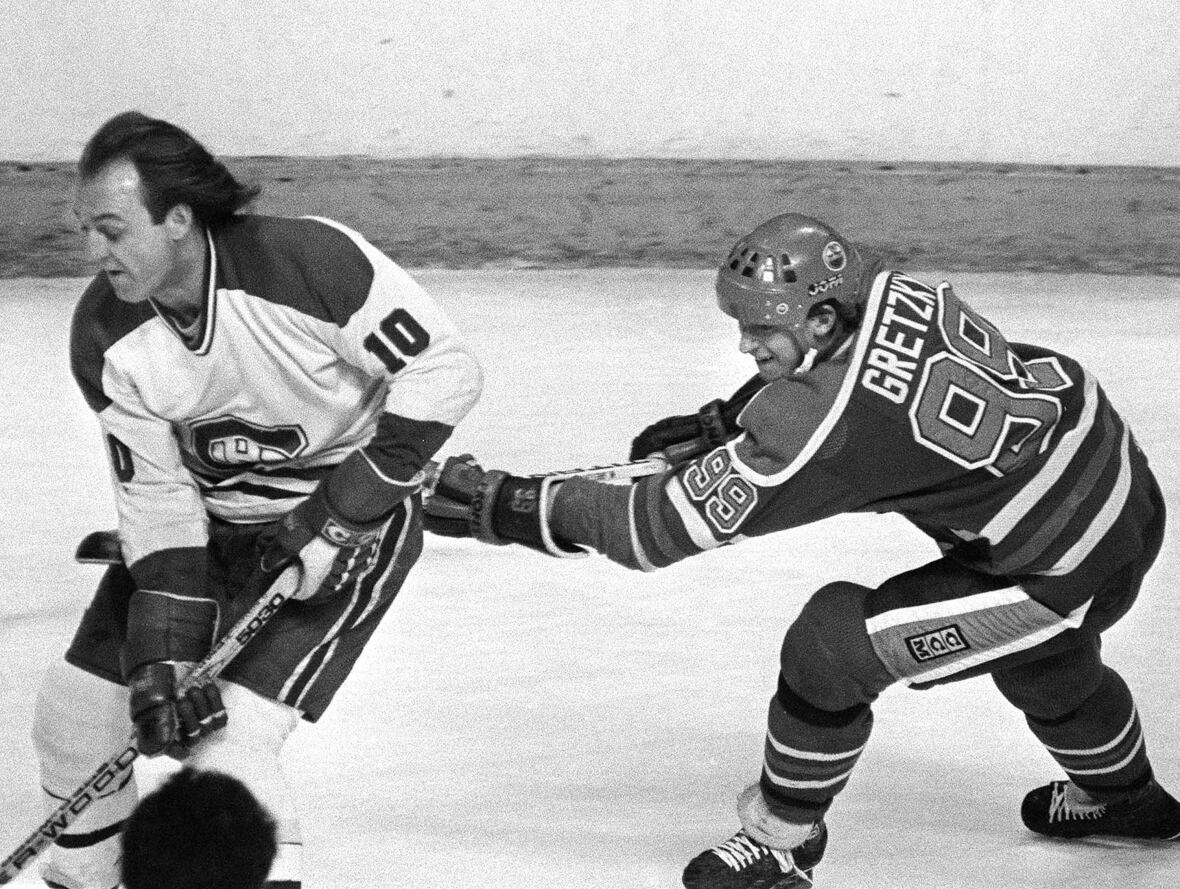 A black and white photo of Guy Lafleur and Wayne Gretzky on the ice.