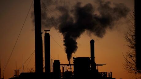 Smoke billows from a chimney of the Solvay factory for production and processing of plastic materials, in Ospiate, near Milan, Italy, Friday, Dec. 14, 2018. The climate change conference, COP24, is closing today in Katowice, Poland. (AP Photo/Luca Bruno) Italy Climate