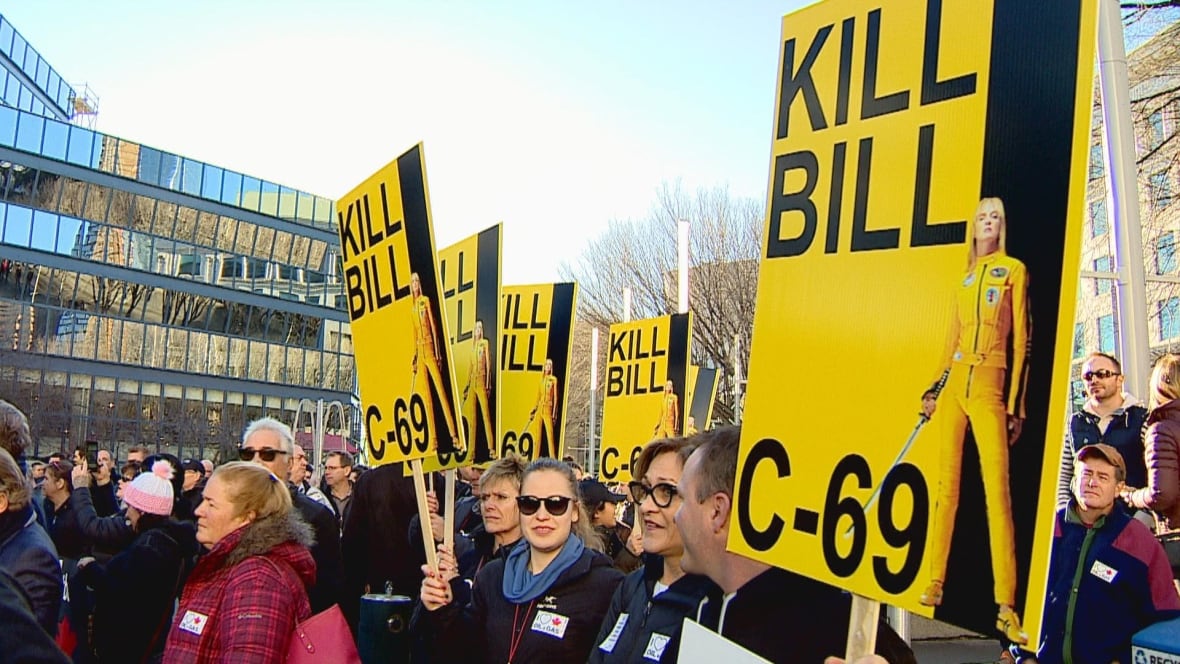 protesters wave yellow placards that pay homage to a Quentin Tarantino film