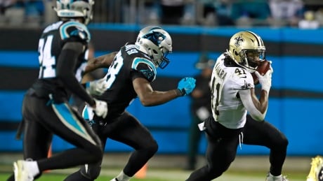 New Orleans Saints' Alvin Kamara (41) runs past Carolina Panthers' Thomas Davis (58) in the second half of Monday night's game. Saints Panthers Football