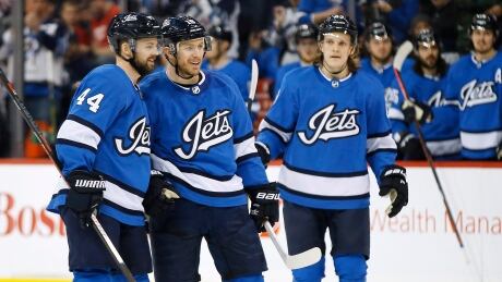 Winnipeg Jets' Josh Morrissey (44), Bryan Little (18) and Sami Niku (83) celebrate Little's goal against the Detroit Red Wings during the second period. redwings-jets