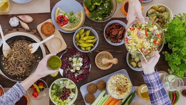 Meat is the default option on many menus. What if the tables were turned?; Friends sharing a healthy vegetarian meal of pasta, bulgur and vegetable tart\. 
