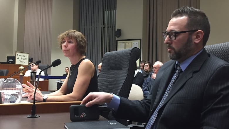 Two people at a council table