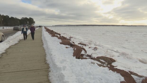The City of Charlottetown wants to protect Victoria Park from coastal erosion. Two people wearing jackets and winter hats walk along the Victoria Park boardwalk.