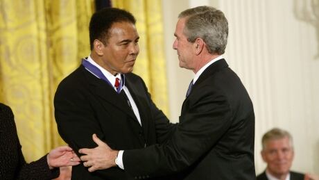 Boxing great Muhammad Ali, pictured in 2005 receiving the Presidential Medal of Freedom from President George W. Bush, will have his hometown Louisville airport named after him. Ali died in 2016. 6448973