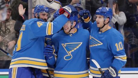 Vince Dunn, centre, is congratulated by teammates Robert Bortuzzo, left, and Brayden Schenn after his second-period goal during the Blues' 3-2 win against the Ottawa Senators on Saturday. dunn-vince-011919