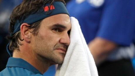 Switzerland's Roger Federer wipes the sweat from his face during a break in his fourth round match against Greece's Stefanos Tsitsipas at the Australian Open tennis championships in Melbourne, Australia, on Sunday. Australian Open Tennis