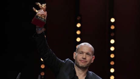 Director Nadav Lapid holds aloft the golden bear for best film for 'Synonyms' onstage at the award ceremony of the 2019 Berlinale Film Festival in Berlin, Germany, Saturday, Feb. 16, 2019. (AP Photo/Markus Schreiber) Germany Berlin Film Festival Award Ceremony 2019