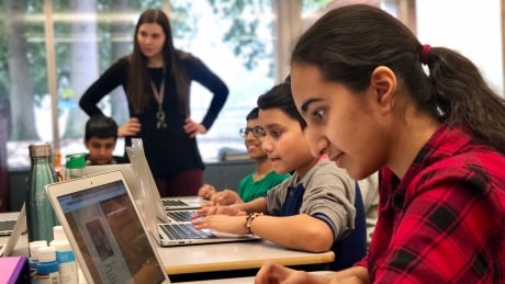 Vushara Mudassar and her classmates at Surrey’s Senator Reid Elementary answer quiz questions on the Kids Boost Immunity website as her teacher Tanis Filiatrault watches over. The school leads the country in participation on the site. BCCDC